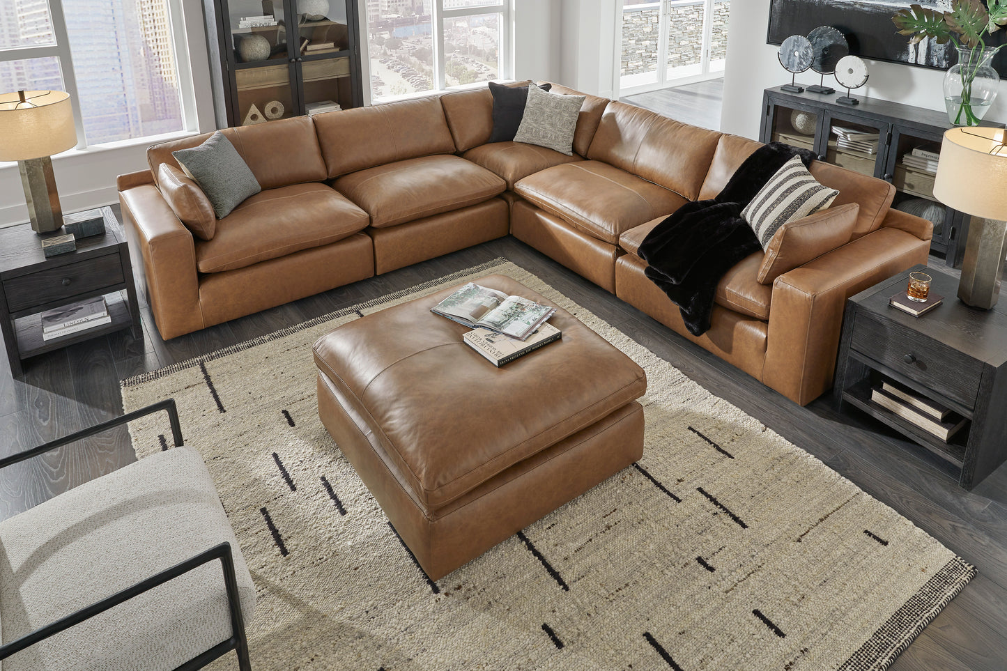 Brown leather sectional sofa with ottoman in a living room setting.
