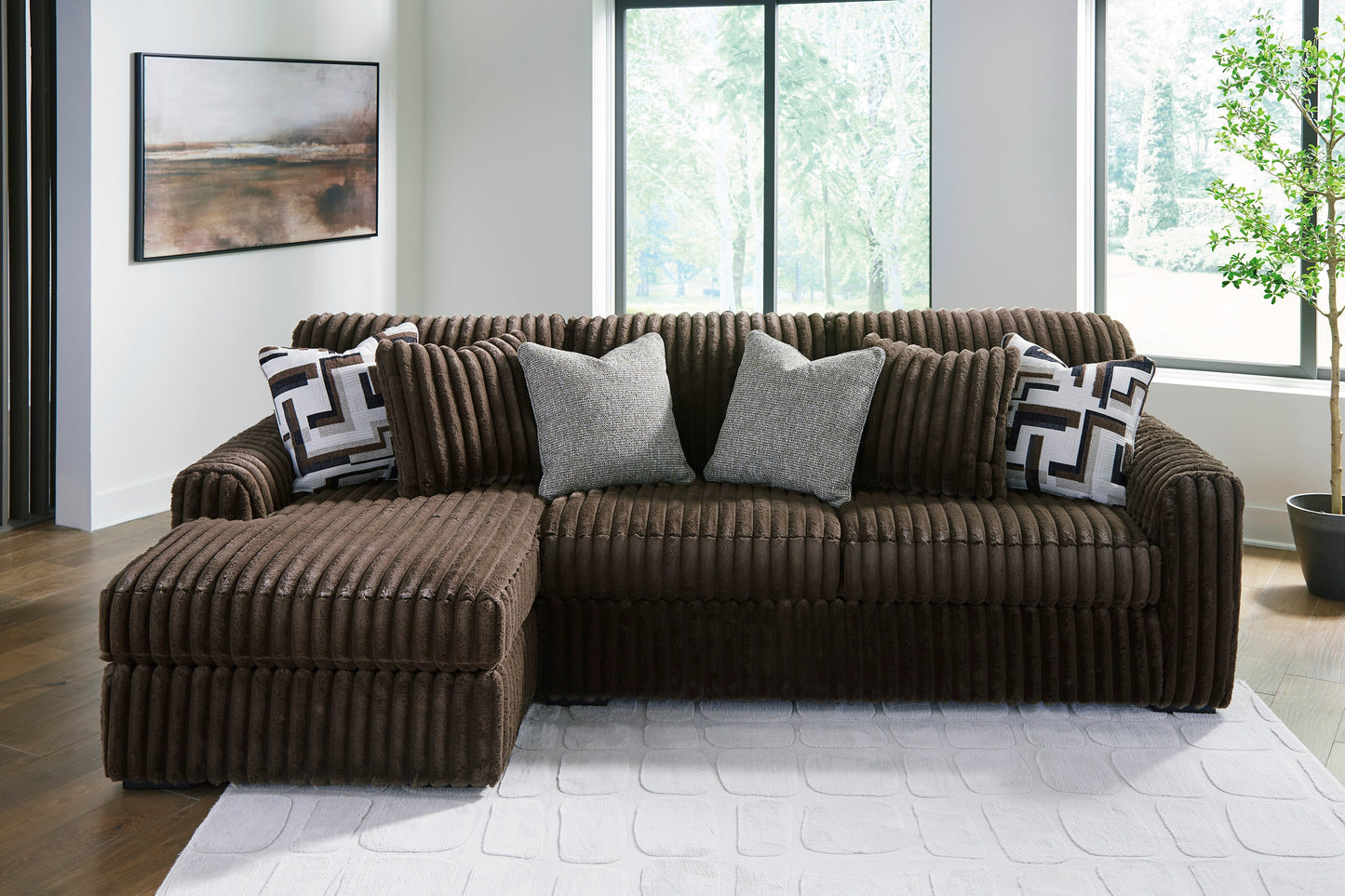 Brown sectional sofa with decorative pillows in a modern living room.