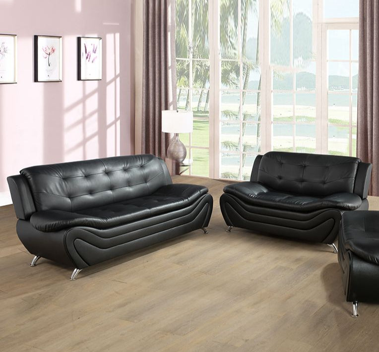 Black leather sofa set in a living room with large windows and curtains.