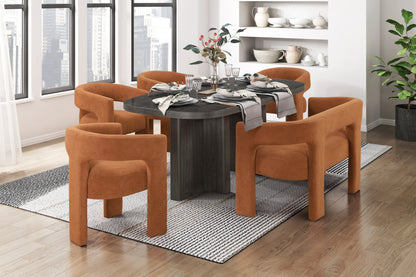 Dining room with a round black table and orange chairs, cityscape visible through window.