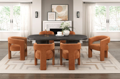 Dining room with a black round table and orange chairs in a well-lit room.