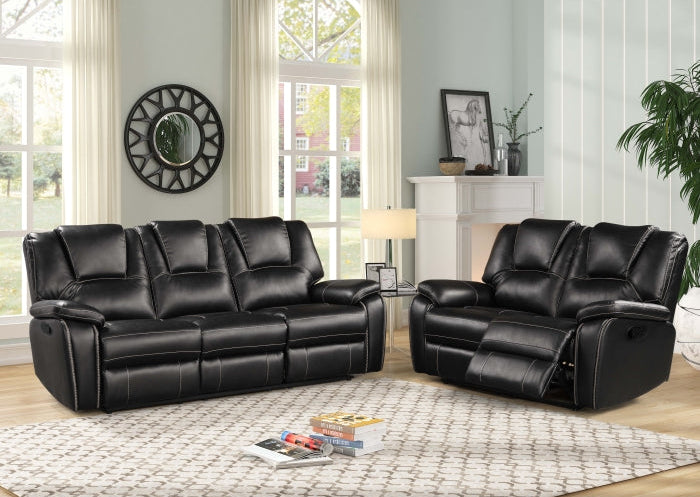 Black leather reclining sofa set in a living room setting with decor elements.