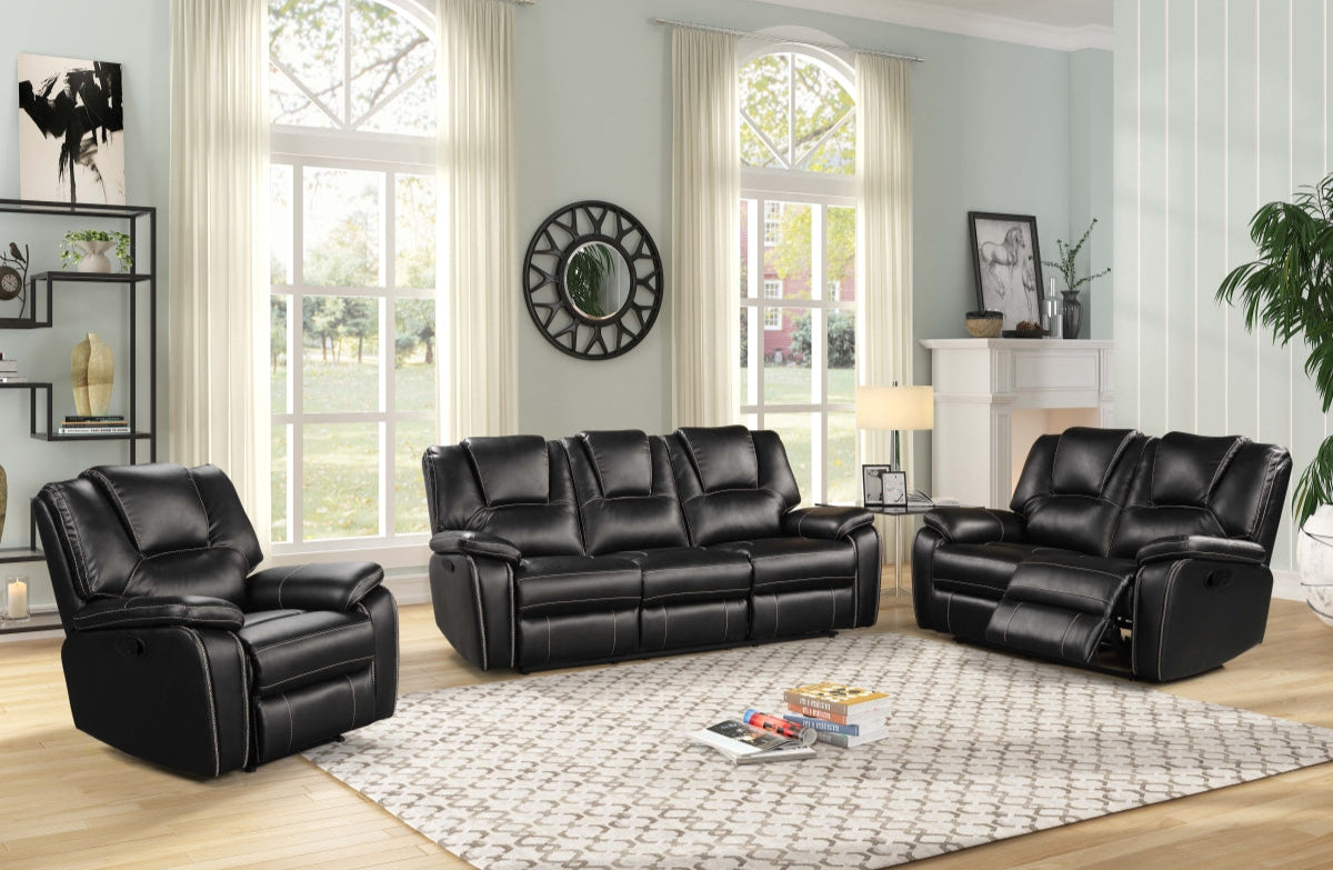 Black leather reclining sofa set in a living room with large windows and decorative elements.