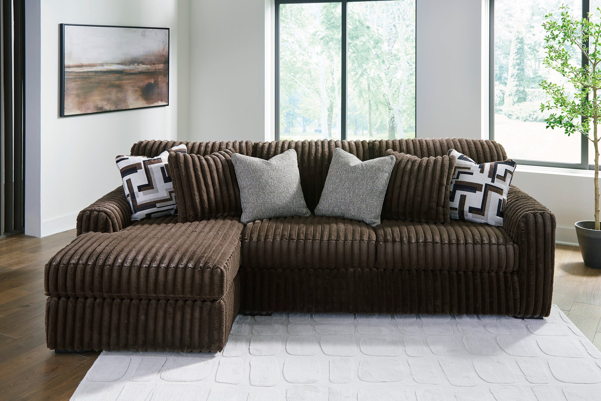 Brown sectional sofa with decorative pillows in a modern living room.
