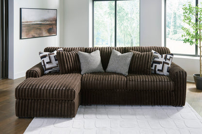 Brown sectional sofa with decorative pillows in a modern living room.