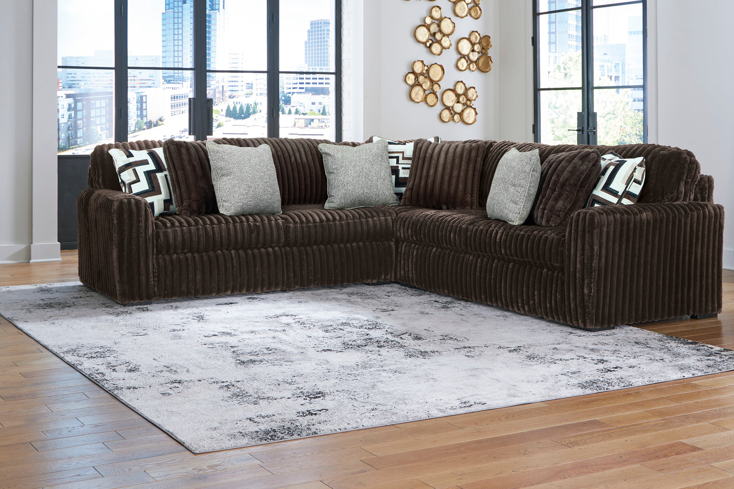 Brown sectional sofa with patterned cushions in a living room setting.