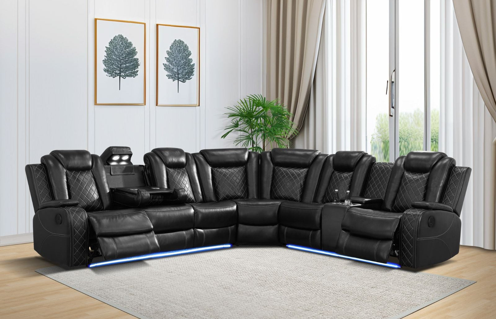 Black leather sectional sofa in a living room with light wood flooring and white walls.