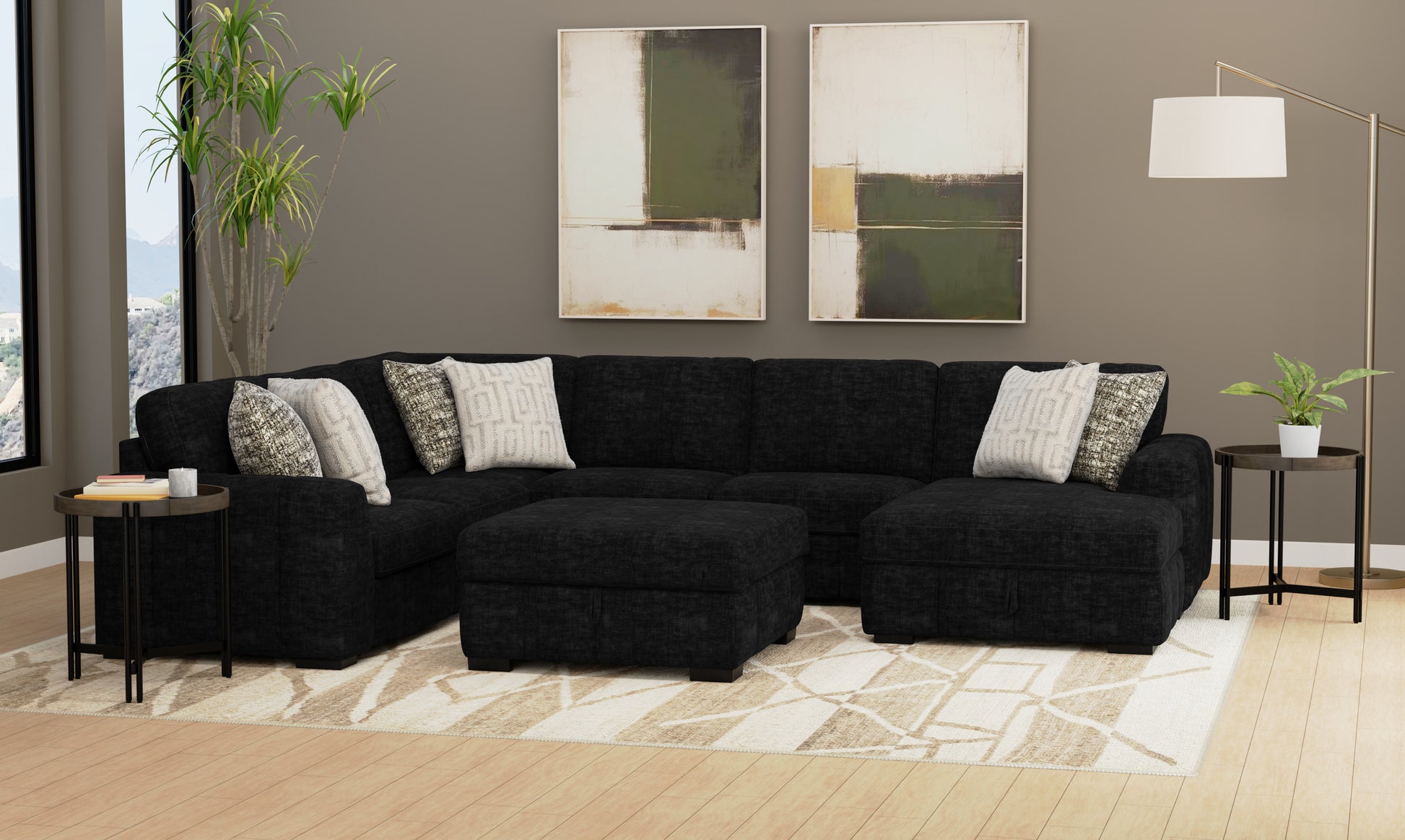 Modern living room with a black sectional sofa, side tables, and abstract art on the wall.
