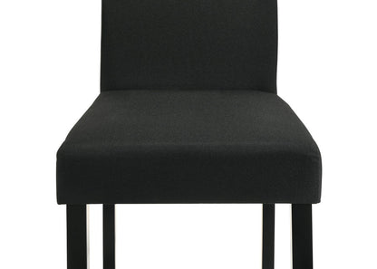 Close-up of Resia Collection dining chair with plush charcoal upholstery and sleek black legs, offering comfort and understated luxury.